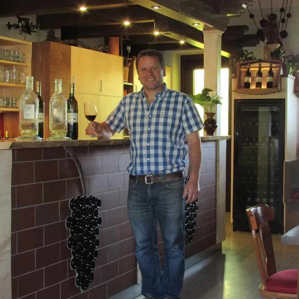 Robert mit einem Glas Rotwein an der Schank im Buschenschank